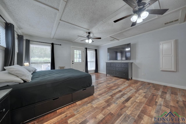 bedroom featuring ornamental molding, hardwood / wood-style floors, and a textured ceiling