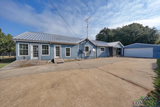 single story home featuring an outbuilding and a garage