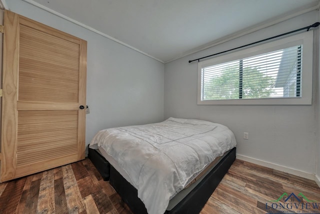 bedroom featuring ornamental molding and dark hardwood / wood-style flooring