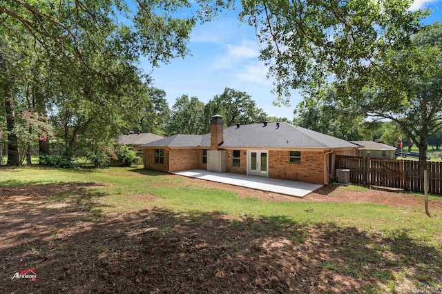 rear view of property featuring a patio area, cooling unit, a lawn, and french doors