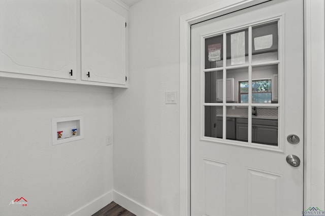 washroom with washer hookup, cabinets, and dark hardwood / wood-style flooring