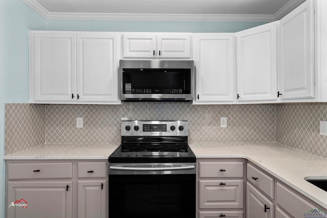 kitchen with backsplash, white cabinets, stainless steel appliances, and crown molding