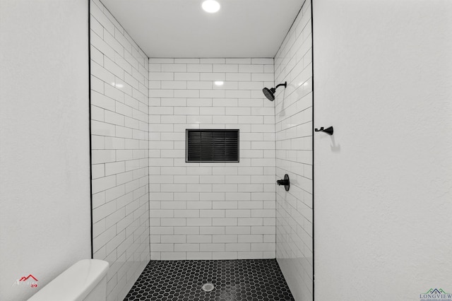 bathroom with toilet and a tile shower