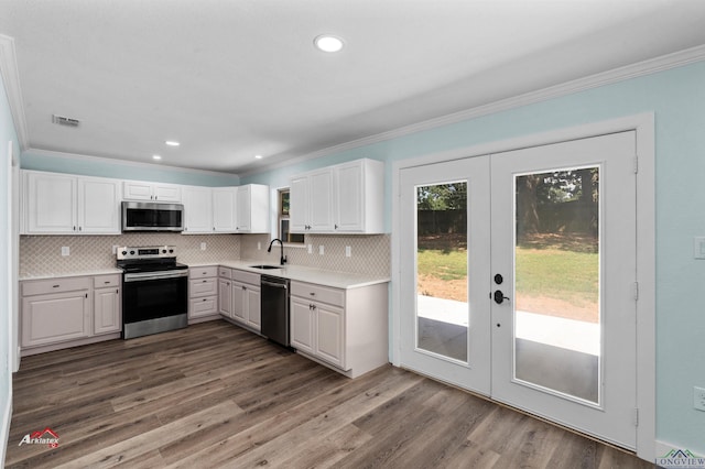 kitchen with sink, white cabinetry, appliances with stainless steel finishes, ornamental molding, and french doors