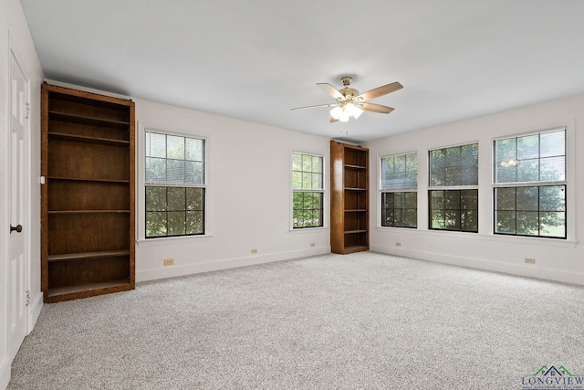 unfurnished room with ceiling fan and carpet