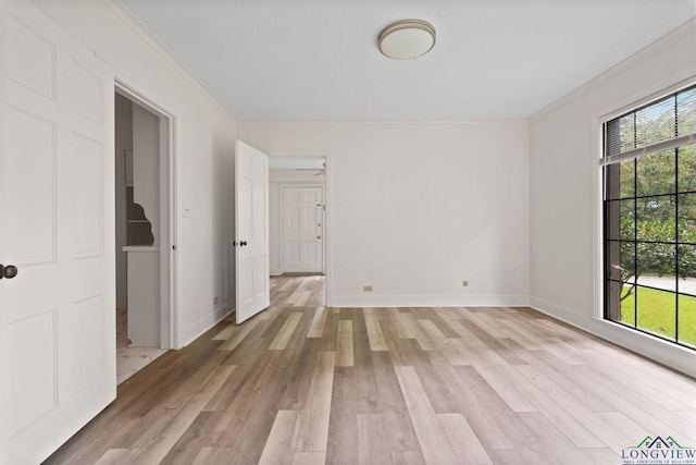 empty room featuring ceiling fan, light hardwood / wood-style flooring, and crown molding