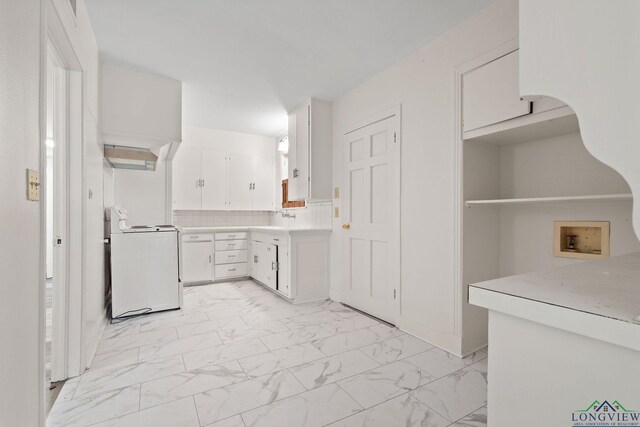 kitchen with backsplash, white cabinetry, stove, and sink