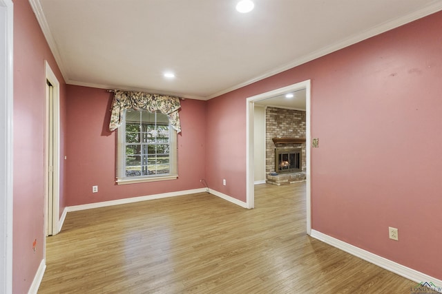 unfurnished dining area featuring light hardwood / wood-style floors, a brick fireplace, and crown molding