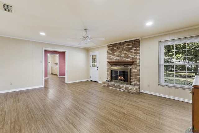 unfurnished living room with ceiling fan, a fireplace, hardwood / wood-style floors, and ornamental molding