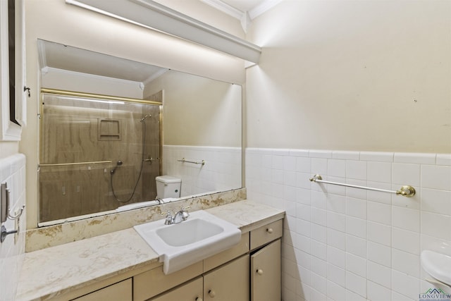 bathroom featuring vanity, toilet, ornamental molding, and tiled shower