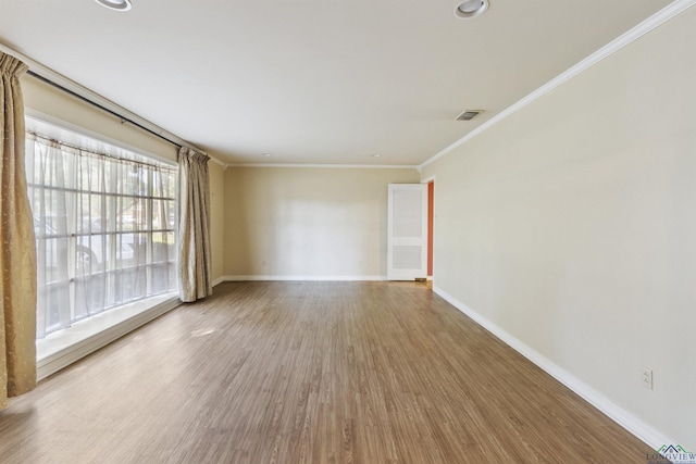 spare room featuring wood-type flooring and ornamental molding