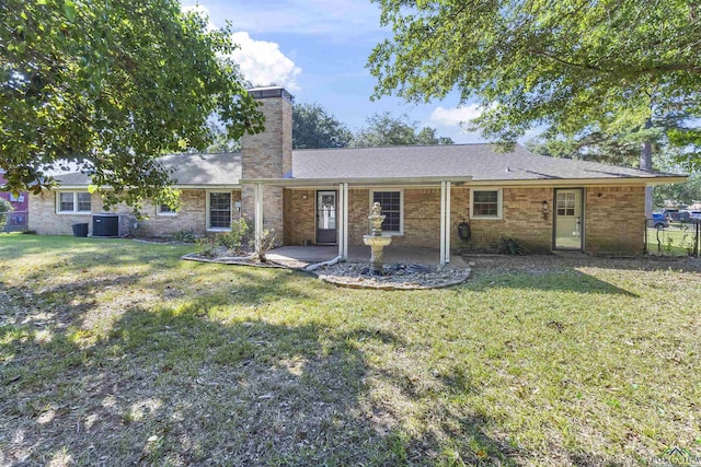 rear view of property featuring a yard and central AC unit