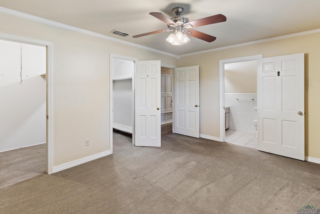 unfurnished bedroom with ceiling fan, ornamental molding, light carpet, and ensuite bath