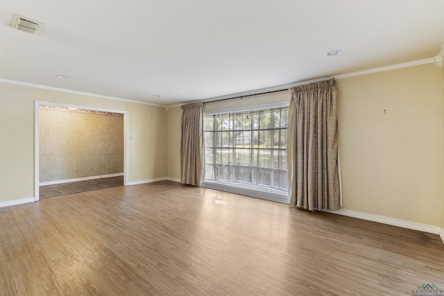 spare room featuring ornamental molding and hardwood / wood-style flooring