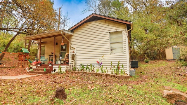 view of side of home featuring a porch and a shed