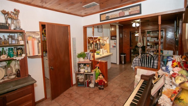 dining space featuring ceiling fan, wood walls, wooden ceiling, and crown molding