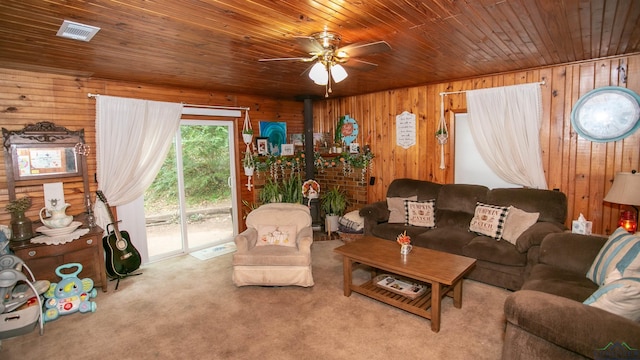 living room featuring wooden ceiling, light colored carpet, ceiling fan, and wooden walls