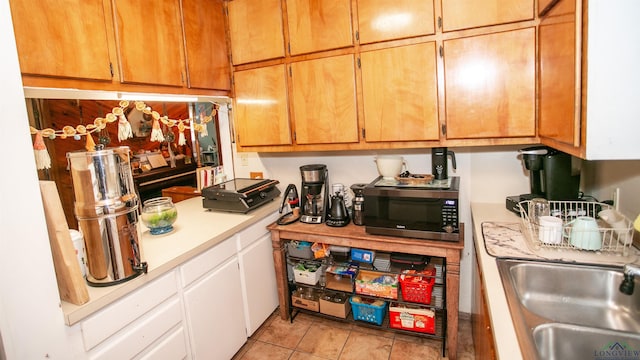 kitchen featuring light tile patterned floors and sink