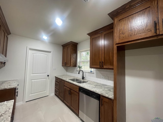 kitchen featuring stainless steel dishwasher, light stone countertops, sink, and decorative backsplash