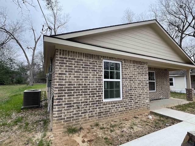 view of side of property featuring central AC unit and a patio