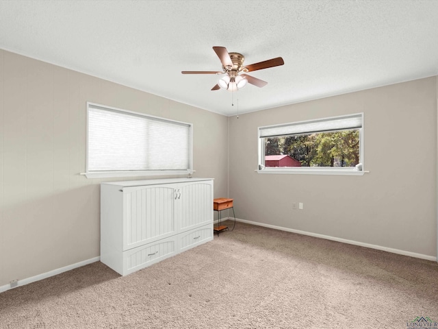 unfurnished bedroom with carpet flooring, ceiling fan, and a textured ceiling