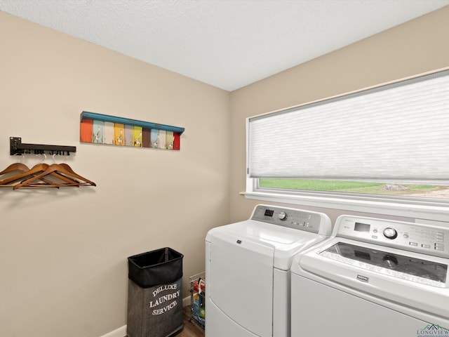 washroom featuring a textured ceiling and washing machine and dryer