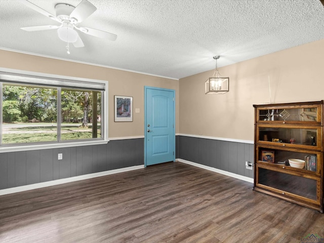 unfurnished room with a textured ceiling, ceiling fan with notable chandelier, and dark hardwood / wood-style floors