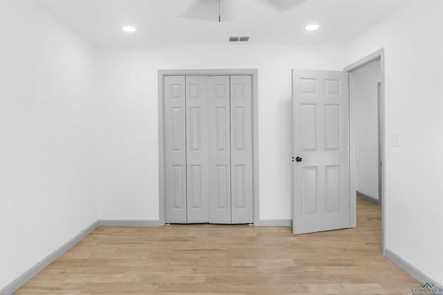 unfurnished bedroom with a closet, light hardwood / wood-style flooring, and ceiling fan