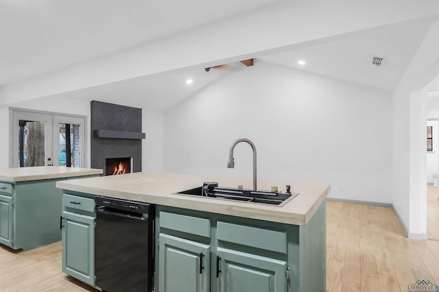 kitchen with a center island with sink, lofted ceiling with beams, and green cabinets