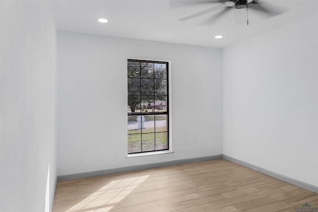 empty room with ceiling fan and light hardwood / wood-style flooring