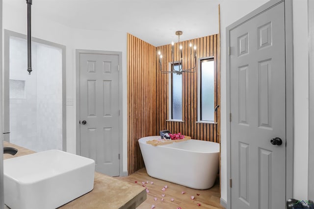 bathroom with a tub to relax in and an inviting chandelier