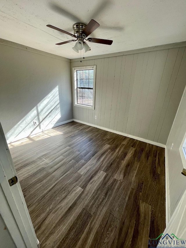 616 W Center St, White Oak, TX 75693 - spare room featuring wood finished floors, baseboards, ceiling fan, and wood walls