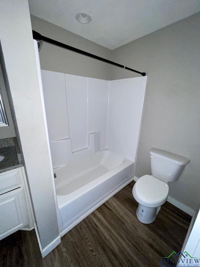 616 W Center St, White Oak, TX 75693 - bathroom featuring wood finished floors, toilet, tub / shower combination, vanity, and baseboards
