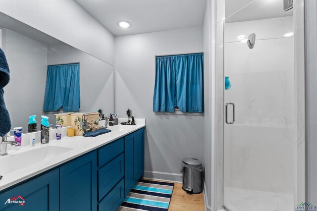 3315 N US Highway 259, Kilgore, TX 75662 - bathroom with wood finished floors, a shower stall, double vanity, and baseboards