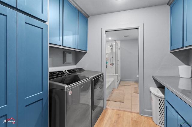 3315 N US Highway 259, Kilgore, TX 75662 - laundry room featuring washer and clothes dryer, cabinet space, baseboards, and light wood-type flooring