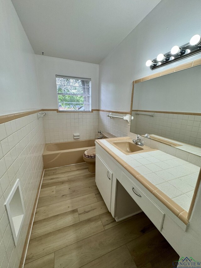 1506 Scenic Dr, Longview, TX 75604 - bathroom featuring tile walls, toilet, vanity, a bath, and wood finished floors