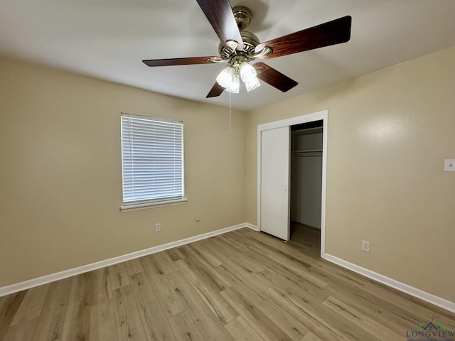 unfurnished bedroom featuring baseboards, light wood-type flooring, and a closet
