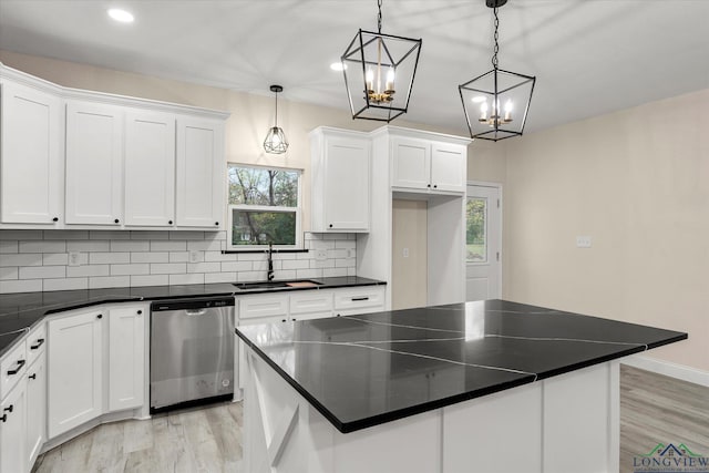 kitchen featuring a kitchen island, dishwasher, sink, white cabinets, and hanging light fixtures