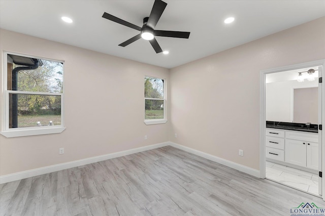 unfurnished bedroom with ceiling fan, connected bathroom, and light hardwood / wood-style floors