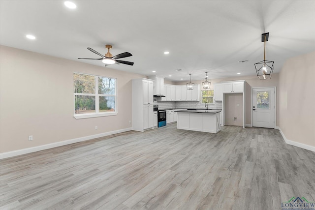 unfurnished living room with light hardwood / wood-style floors and ceiling fan