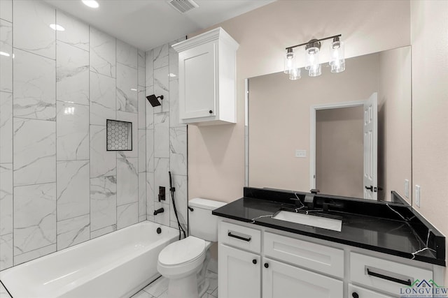 full bathroom featuring vanity, tiled shower / bath, and toilet