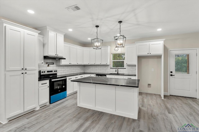 kitchen featuring electric stove, hanging light fixtures, and white cabinets