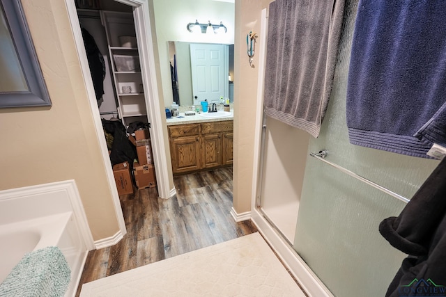 bathroom featuring hardwood / wood-style floors, vanity, and separate shower and tub