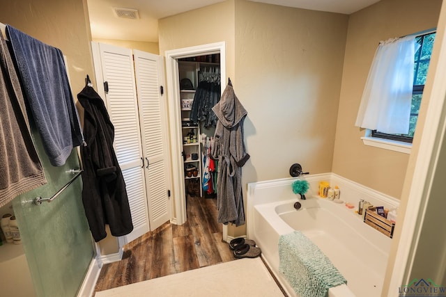 bathroom with hardwood / wood-style flooring and plus walk in shower