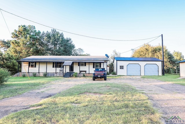 ranch-style home with an outbuilding, a garage, covered porch, and a front yard