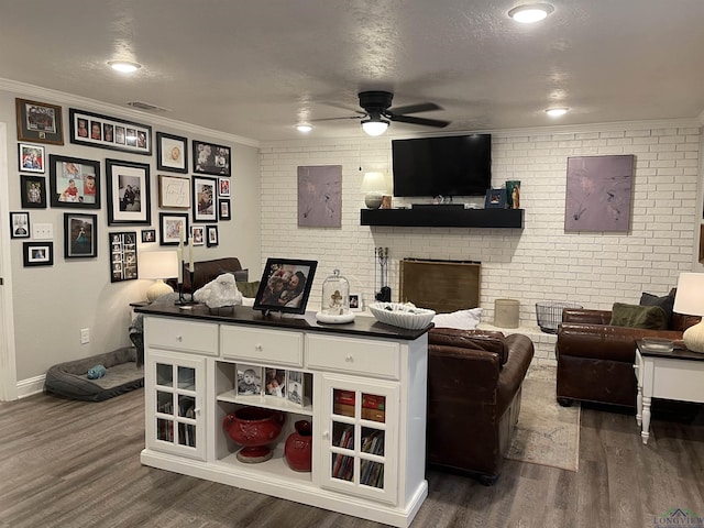 living room featuring a textured ceiling, dark hardwood / wood-style flooring, ceiling fan, and brick wall