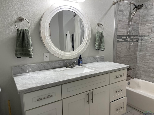 bathroom with tile patterned floors, vanity, and tiled shower / bath