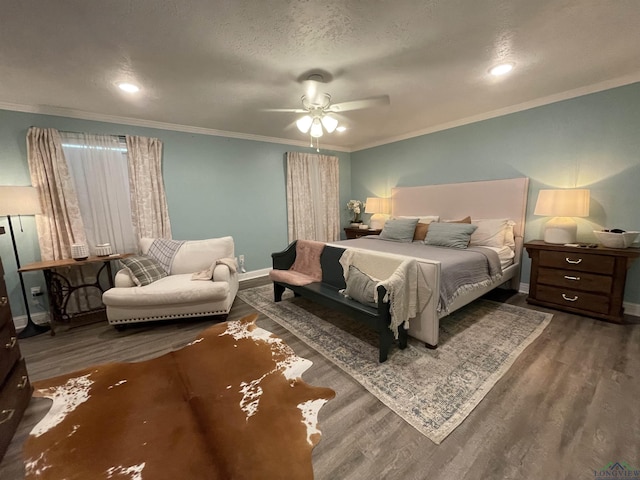 bedroom featuring a textured ceiling, dark wood-type flooring, ceiling fan, and ornamental molding