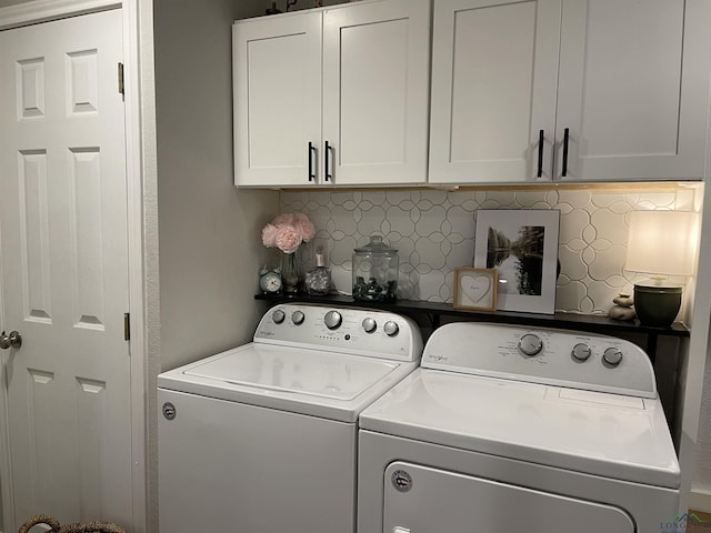 laundry area with washing machine and dryer and cabinets