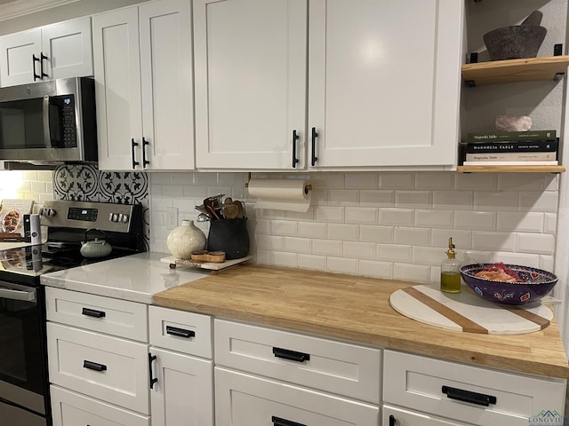 kitchen with white cabinets, backsplash, and stainless steel appliances